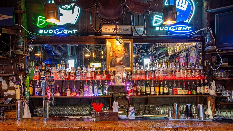 View of bar with liquor bottles, beer taps and neon signs