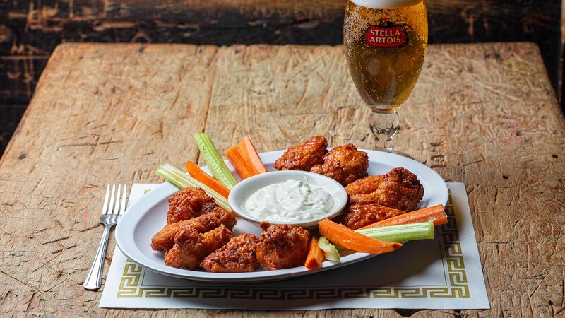 Chicken wings appetizer with ranch dressing and side of carrots and celery sticks